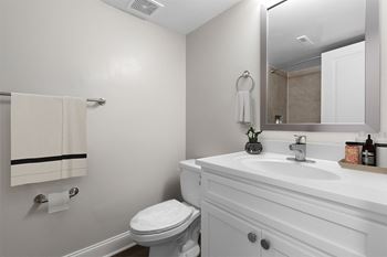 A bathroom with a sink toilet and mirror 
